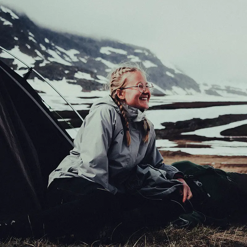 Woman camping in a tent in cold weather
