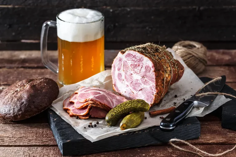Smoked ham and beer on table